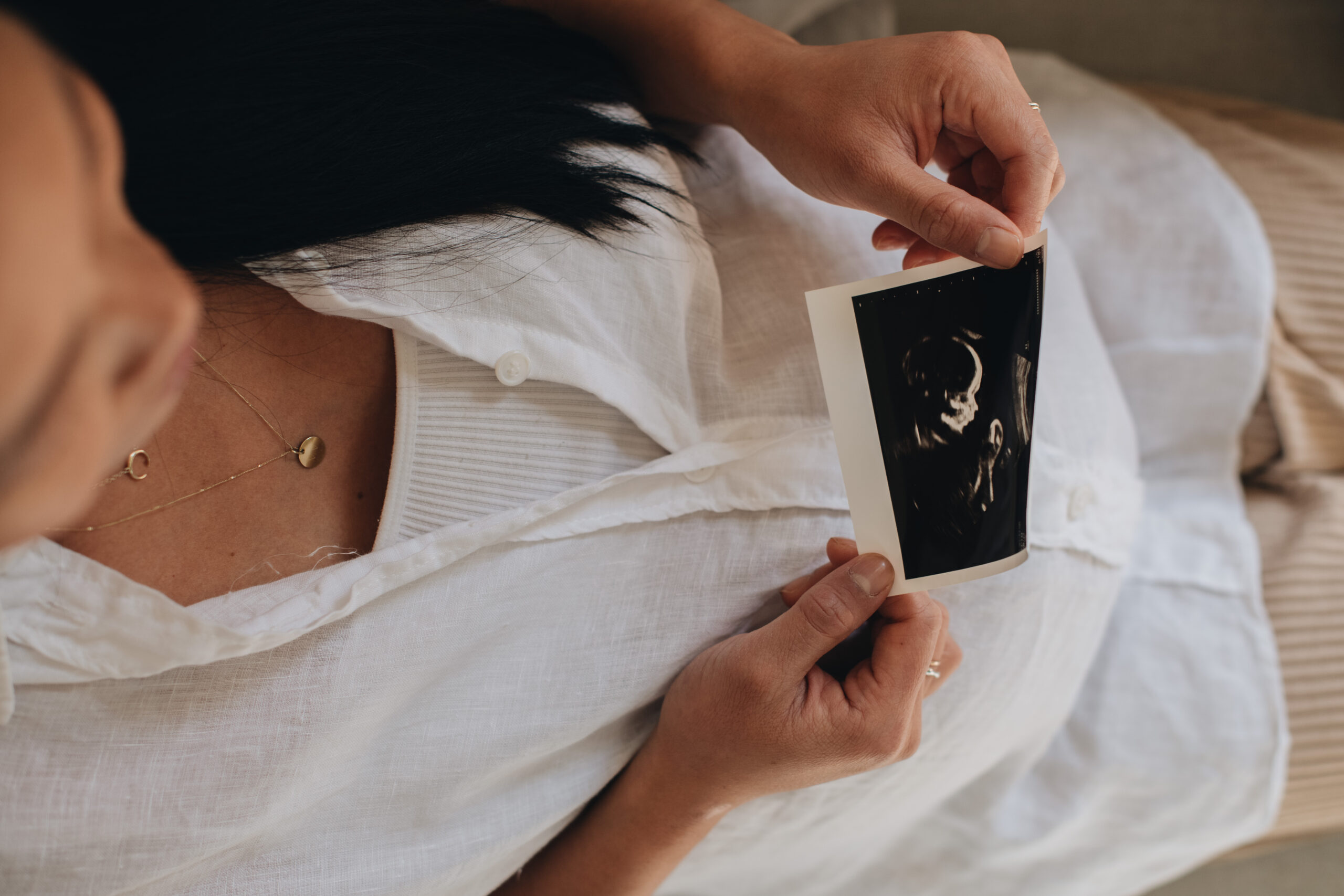 woman holding ultrasound picture