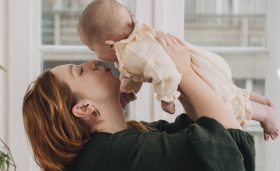 mother holding her baby and kissing